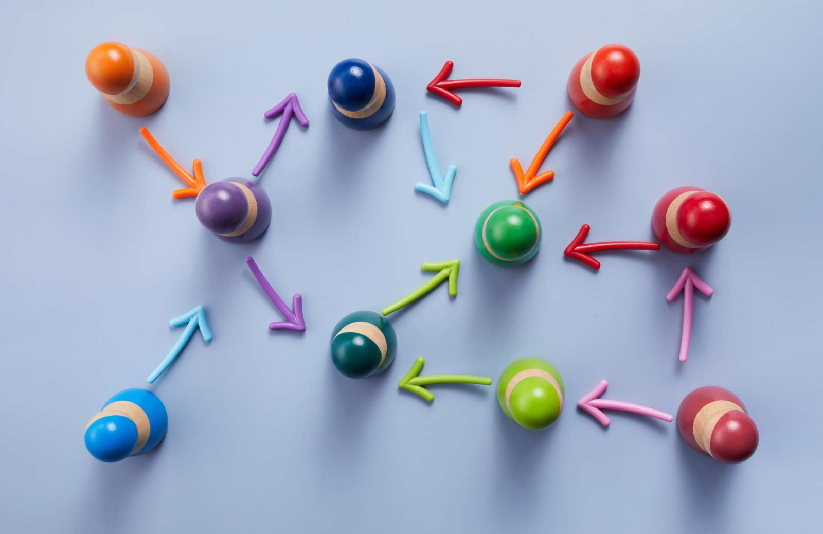 An assortment of colorful wooden pegs with arrows linking between each to one another